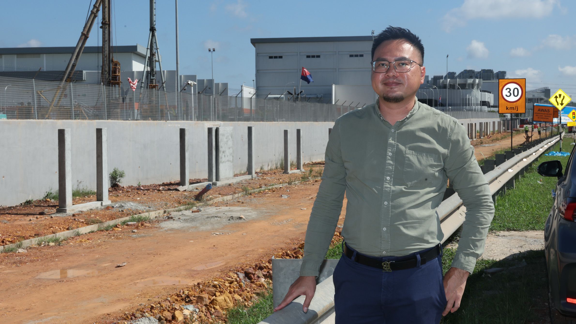 Eric Yong  stands by a construction site